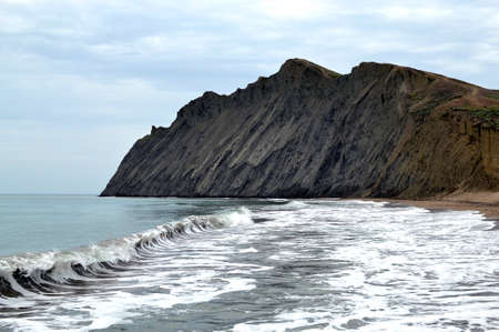 Blue sky, blue sea and green trees on shore. Waves, white clouds and sea foam, yellow sand beach.の写真素材