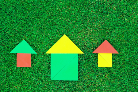 House and sun made of tangram figures on natural grass.の写真素材