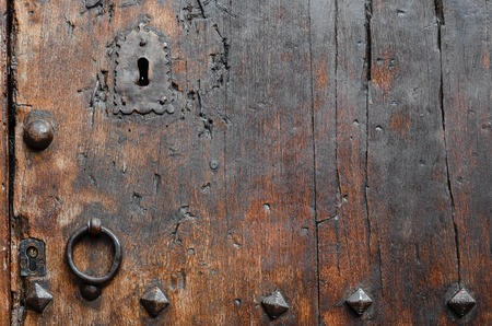 Antique wooden door close-up  and rusty iron knocker.の写真素材