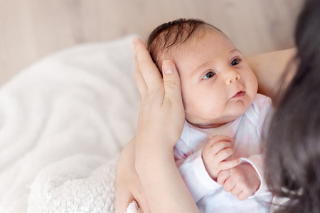 Mother with her newborn baby. Mother is holding her little baby girl.  Photo with the effect of...