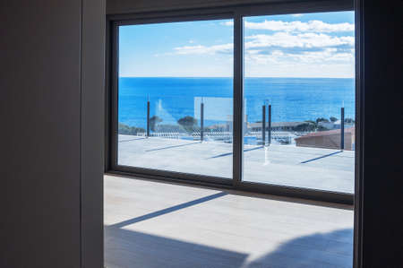 Empty rooms in a new house with large windows overlooking the sea. Automatic blinds. Glass partition terrace.のeditorial素材