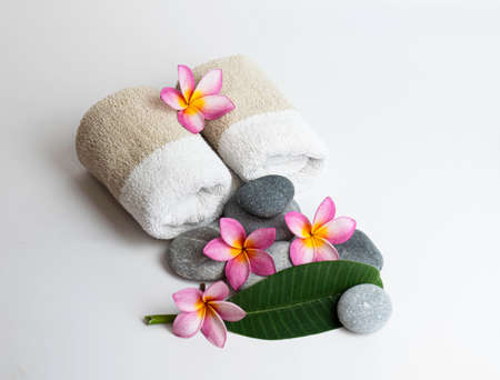 Roll towel with frangipani flower with leaf and spa stonesの写真素材