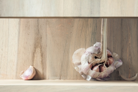 Garlic head and clove on a kitchen shelf の写真素材