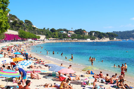 VILLEFRANCHE-SUR-MER, FRANCE - JULY 26, 2016: Crowded summer beach on Mediterranean sea near Nice, Cote d'Azur, French rivieraのeditorial素材