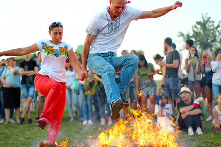KYIV, UKRAINE - JULY 6, 2018: People jump over the flames of bonfire during the traditional Slavic celebration of Ivana Kupala holiday in Pirogovo open-air ukrainian folk museumのeditorial素材