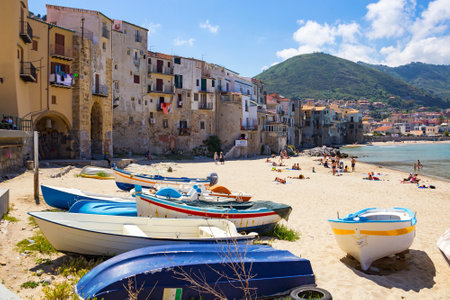 CEFALU, ITALY - MAY 12, 2018: People sunbathing on beautiful small beach in Cefalu old town on Mediterranean sea, Sicilyのeditorial素材