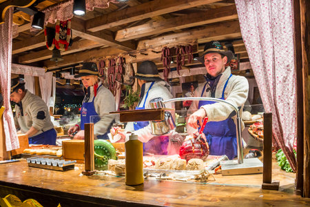 HAMBURG, GERMANY - DECEMBER 14, 2018: Food stall with traditional meat and sausages at Christmas market on the central square near cityhallのeditorial素材