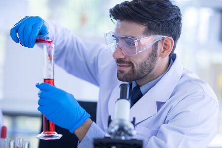 Male scientists is experimenting with chemicals in the laboratory. Concept, The scientists wear...