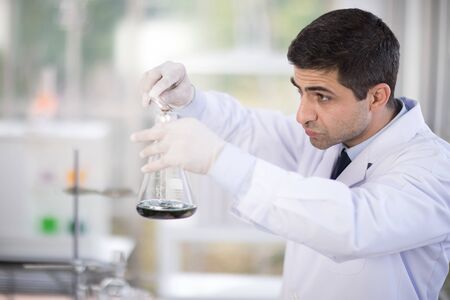 Handsome medical doctor in white coat is Researching in laboratory
