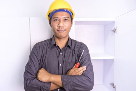 Asian male furniture technician wearing a hat, looking at the cameraの写真素材