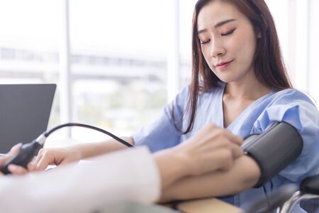 Doctor measuring arterial blood pressure for asian women patient. Concept Health care in hospitalの写真素材