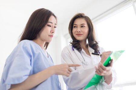 Asian female doctor is explaining diagnosis to her female patient. Medicine and health care, female doctors and female patients conceptの写真素材