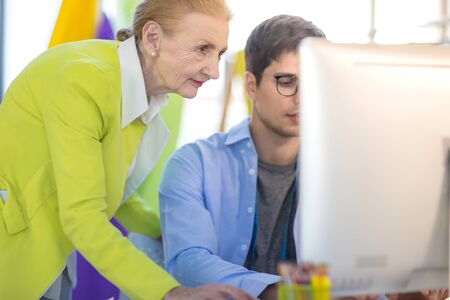 Senior female designer is talking to a male designer in a tailor shop.の写真素材