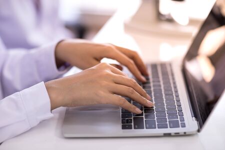 Hands typing on laptop keyboardの写真素材