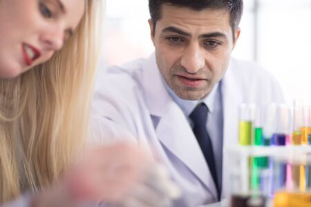 Male scientists and white female scientists are experimenting with chemicals in the laboratory.の写真素材