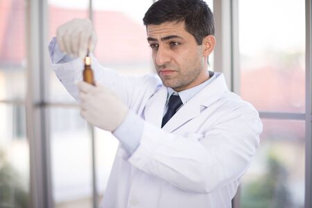 Handsome medical doctor in white coat is Researching in laboratory