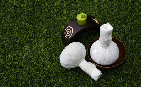 set of herbal ball and scented candle on greensward with spa concept and copy spaceの写真素材