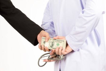 Man in black suit is given bribe to doctor on white background, Business concept Corruption in health care industry.の写真素材