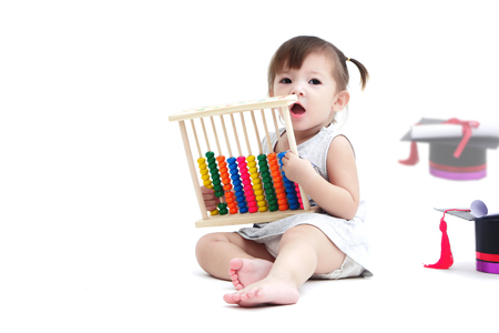 A mestizo lovely girl playing with abacus is calculator make from wooden paint full color and a graduate hat, a roll of certificate with red ribbon lay  isolated on white background and copy spaceの写真素材
