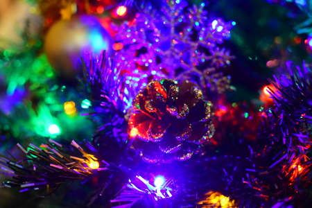 christmas cone on a garland-decorated treeの写真素材