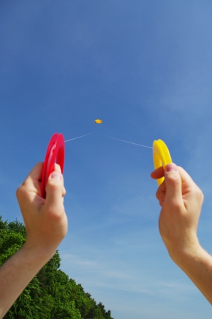 The person keeping hands up and holding a colorful kite on a beach in Polandの写真素材