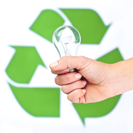 Bulb in a hand against recycling sign backgroundの写真素材