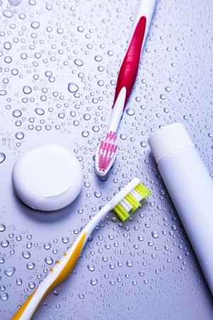 Two tooth-brushes, toothpaste, dentalfloss and water dropsの写真素材