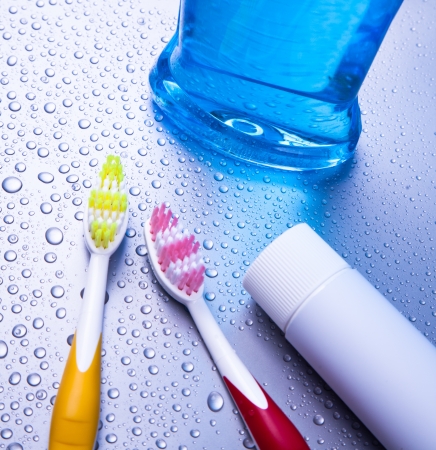 Two toothbrushea, toothpaste and mouthwash with waterdropsの写真素材