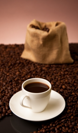 cup of coffee and burlap sack on roasted coffee beansの写真素材