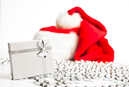 A gift box standing next to Santa Claus red hat の写真素材
