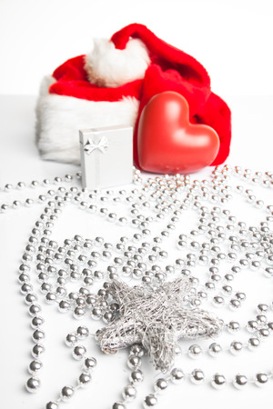 A gift box and a ceramic heart standing next to Santa Claus red hat の写真素材