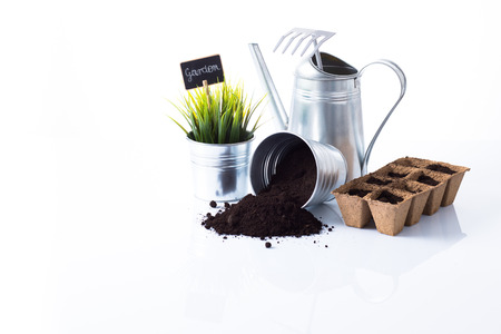 Subtle metal gardening items and flowers composition isolated on whiteの写真素材