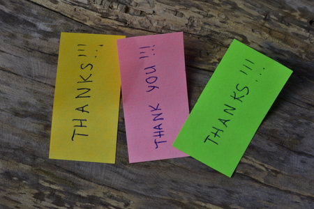 Message thanks thank you on pink green and yellow sticky notes day on wooden board textured...