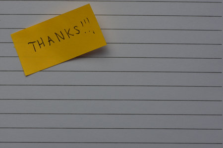 Message thanks thank you on yellow sticky note day on notebook line paper background