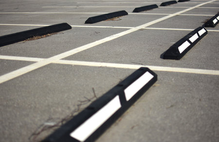 Empty parking space with white lines and curb stops.の写真素材