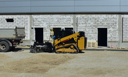 Mini excavator standing in big construction site. Small tractor working in construction site.