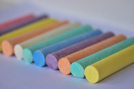 Side angle view of large pastel chalk sticks arranged in neat rows. Artistic texture and vibrant...