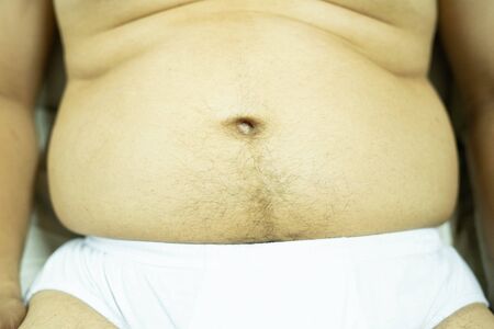 Fat man with a big belly. Diet concept.focus around front of picture- Image.の写真素材