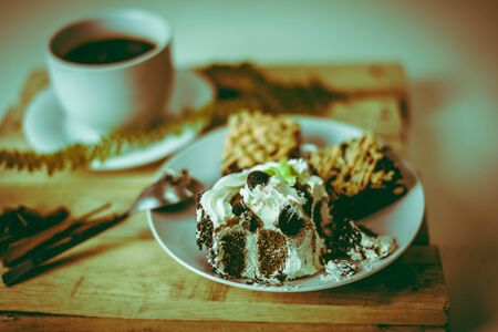 Cup of black coffee and cake on a wooden table. - Imageの写真素材