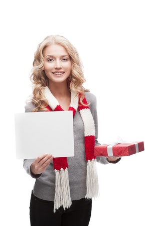 young happy smiling casual  blond woman holding red christmas gift and sign isolated on whiteの写真素材