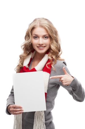 young happy smiling casual  blond woman pointing at sign isolated on whiteの写真素材