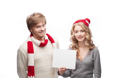 young casual caucasian couple in red scarf and hat holding sign with nice smilesの写真素材