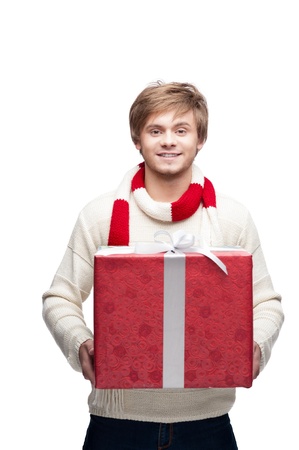 portrait of young cheerful caucasian man which holding big red christmas gift with nice smileの写真素材