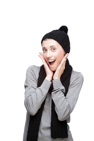 studio portrait of young attractive caucasian girl in winter clothing with surprised expression on white backgroundの写真素材