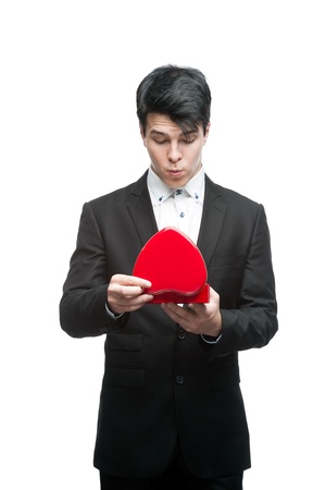 young funny business man holding red Valentine heart isolated on whiteの写真素材