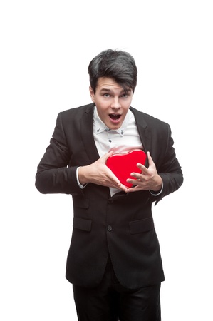 young funny business man holding red Valentine heart isolated on whiteの写真素材