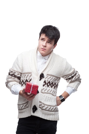 young funny caucasian brunette man in winter clothing holding christmas gift isolated on whiteの写真素材