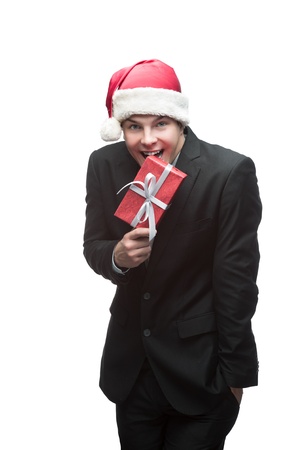 young happy business man in santa hat holding red christmas gift isolated on whiteの写真素材
