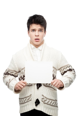 young caucasian brunette man in winter clothing holding sign and looking at camera with scared expression isolated on whiteの写真素材