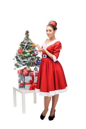 young cheerful retro girl standing near christmas tree isolated on whiteの写真素材